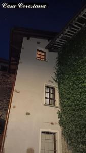 - un bâtiment blanc avec deux fenêtres et un mur vert dans l'établissement Antica torre del castello Casa Ceresiana, à Carabietta