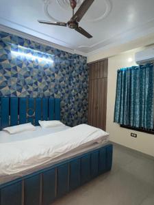 Kashi Anadam HomeStay في فاراناسي: غرفة نوم بسرير مع جدار ازرق