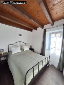 a bedroom with a large bed and a window at Antica torre del castello Casa Ceresiana in Carabietta