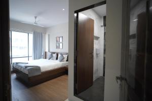 ターネーにあるSUNBRIGHT ROOMS & RESIDENCYのベッドルーム1室(ベッド1台付)、バスルーム(鏡付)