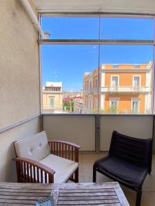 a balcony with two chairs and a window at Abruzzi 81 in Lecce