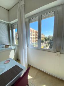 a room with two windows and a table and chairs at Abruzzi 81 in Lecce