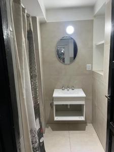 een badkamer met een witte wastafel en een spiegel bij Wine Aparts in Mendoza