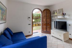 uma sala de estar com um sofá azul e uma televisão em Villa vicino al mare con giardino e parcheggio em Cinquale