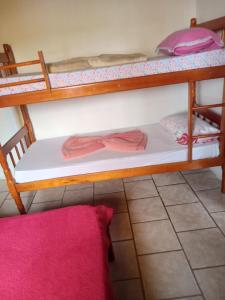 a room with two bunk beds and a pink rug at Pousada paraíso no Mar in Matinhos