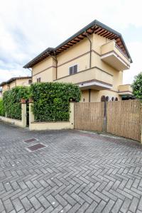 uma casa com uma cerca em frente em Villa vicino al mare con giardino e parcheggio em Cinquale
