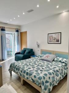 um quarto com uma cama e uma cadeira azul em Hedera Capri B&B em Anacapri