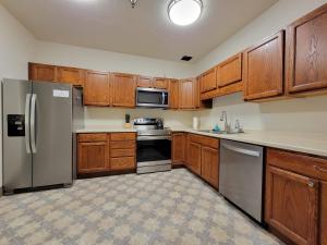 a kitchen with wooden cabinets and stainless steel appliances at City Hall Vault in Rochester