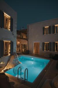 a swimming pool in front of a building at night at Manili Boutique Suites & Villas in Archanes