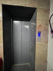 uma porta de elevador de metal numa parede de tijolos em Kashi Anadam HomeStay em Varanasi