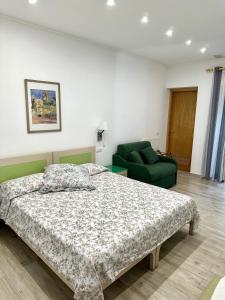 a bedroom with a bed and a green chair at Hedera Capri B&B in Anacapri