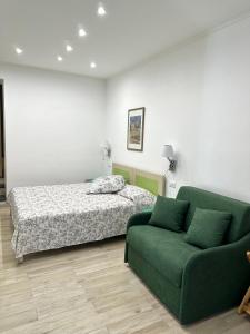 um quarto com uma cama e um sofá verde em Hedera Capri B&B em Anacapri
