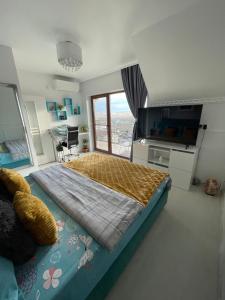 a large bedroom with a large bed and a television at Studio in Panoramic House in Cluj-Napoca