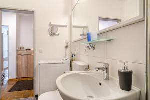 a white bathroom with a sink and a toilet at Ferienwohnung Alex in Meersburg +22 photos