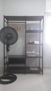 a black shelf with a fan in a room at Apartamento frente Mar! in Santos
