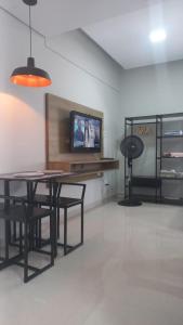 a room with a table and chairs and a tv at Apartamento frente Mar! in Santos