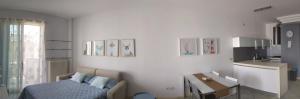a white room with a bed and a kitchen at Appartamento a Riccione con balconcino vista mare in Riccione