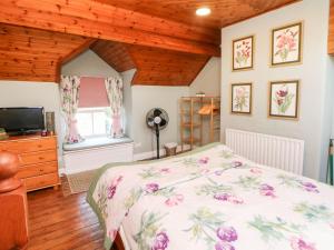 a bedroom with a bed and a tv and a window at Waters Edge in Bakewell