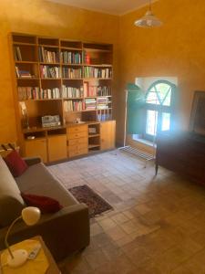 un soggiorno con divano e libreria di Casale San Francesco Casa Pernicoló a Cirò