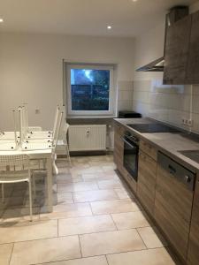 a kitchen with a sink and a table and a window at Möbilierte 3 Zimmer Wohnung mit großer Wohnküche in Dossenheim +6 photos