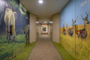 a hallway with paintings of animals on the walls at Gran Hotel del Coto in Matalascañas