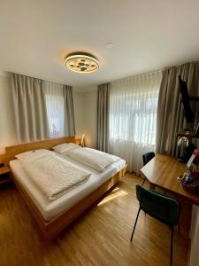 1 dormitorio con cama, mesa y escritorio en Brauerei und Gasthof zum Engel, en Waldstetten