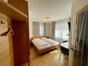 a hotel room with a bed and a desk and a room at Brauerei und Gasthof zum Engel in Waldstetten