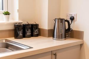 a kitchen counter with two coffee pots on it at Great 4 bedroom home with garden on the Wirral Peninsula in Birkenhead