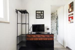 uma sala de estar com televisão numa cómoda em [Dimora di Prestigio] Sulle Colline del Monferrato em Ottiglio
