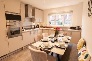 a kitchen with a table and chairs in a kitchen at Great 4 bedroom home with garden on the Wirral Peninsula in Birkenhead