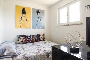 um quarto com uma cama e algumas fotografias na parede em [Dimora di Prestigio] Sulle Colline del Monferrato em Ottiglio