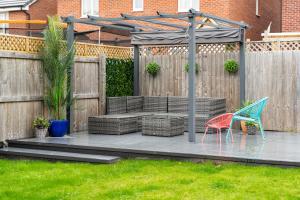 a wooden deck with two chairs and a gazebo at Great 4 bedroom home with garden on the Wirral Peninsula in Birkenhead