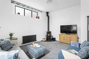 a living room with a couch and a tv at The Granary, Higher Yalberton Farm in Paignton