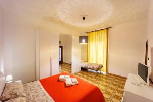 ナポリにあるPeddy Houseの赤いベッドとテレビが備わるホテルルームです。