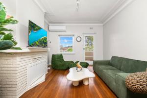 a living room with a green couch and a coffee table at Harbour Bridge View 2BR Resort in Sydney