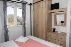 1 dormitorio con cama con espejo y ventana en Bright Heaven en Lakkíon