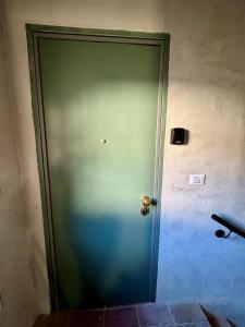 a green door with a gold door knob on a wall at Casa Viaggi in Castel Guelfo di Bologna