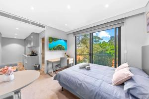 a bedroom with a bed and a desk and a window at Nice and quite studio Roseville in Sydney