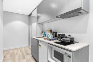 a kitchen with a stove and a microwave at Nice and quite studio Roseville in Sydney