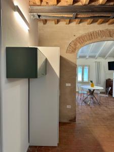 a living room and dining room with a television on a wall at Casa Viaggi in Castel Guelfo di Bologna