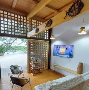 a living room with a baseball bat hanging on the wall at Casa Mari - ilha de Algodoal in Maracanã