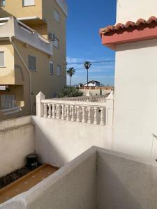 einen weißen Balkon mit einem weißen Zaun und Gebäuden in der Unterkunft Brisa del mar de Valencia in Valencia