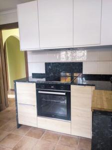 a kitchen with white cabinets and an oven at Alojamiento entero G&G con piscina in Bareyo