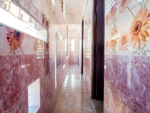 a hallway with flowers painted on the walls of a building at OYO Flagship Ks Elite in Madurai