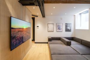 a living room with a large flat screen tv on a wall at Omnia by The Heim Residences in Manchester