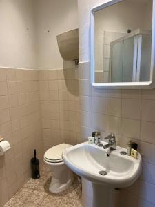 a bathroom with a sink and a toilet and a mirror at Ostello San Marco Cortona in Cortona