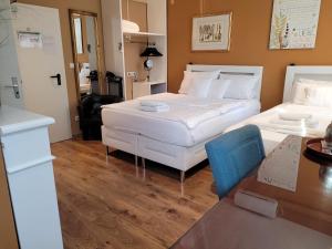 美茵河畔法蘭克福的住宿－弗蘭肯河畔旅館，酒店客房设有两张床、一张桌子和一张桌子。