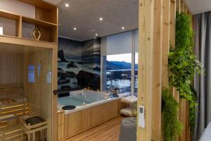 a jacuzzi tub in a room with a large window at Sublime Bnb in Shkodër