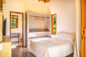 a bedroom with a bed and a desk and a window at Pousada Vila Biribiri Trancoso in Trancoso +62 photos