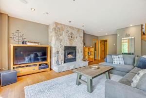 a living room with a couch and a fireplace at The Vista - Magnificent waterfront beach & hot tub in Val des Monts